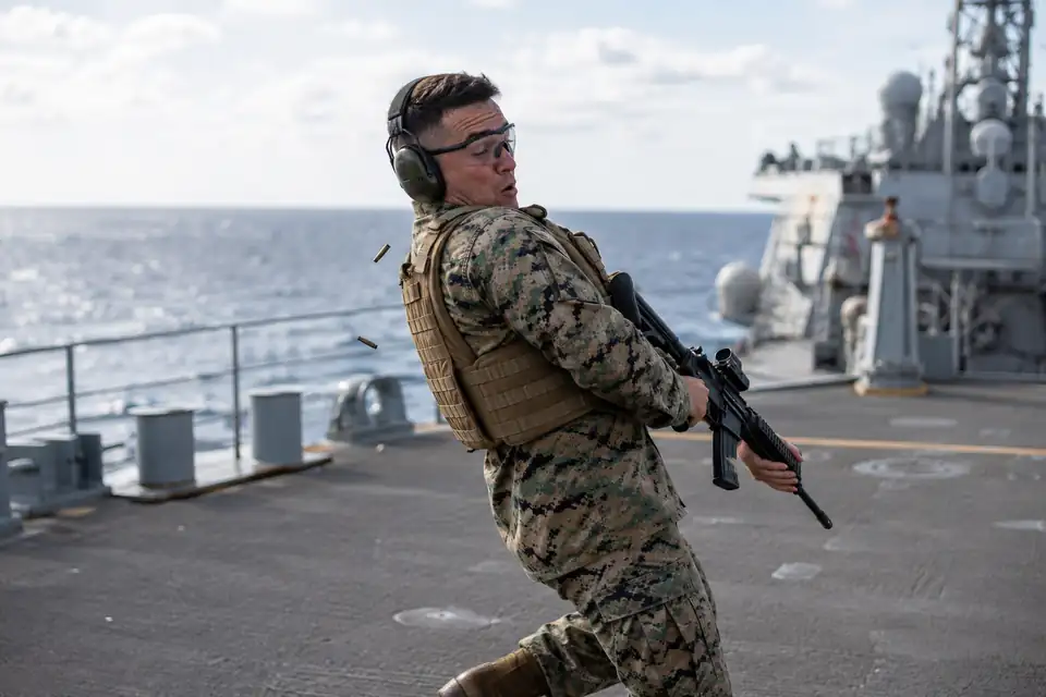 Marine reaccionando al caerle una vaina caliente durante una práctica de tiro