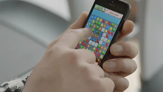 Partida de Candy Crush Saga en un móvil Persona jugando a Candy Crush Saga en un teléfono móvil