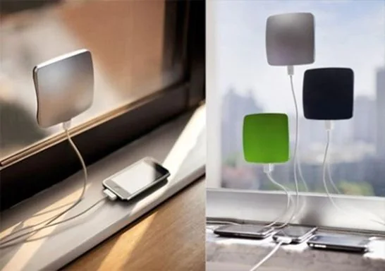 Varios cargadores solares conectados a teléfonos junto a una ventana