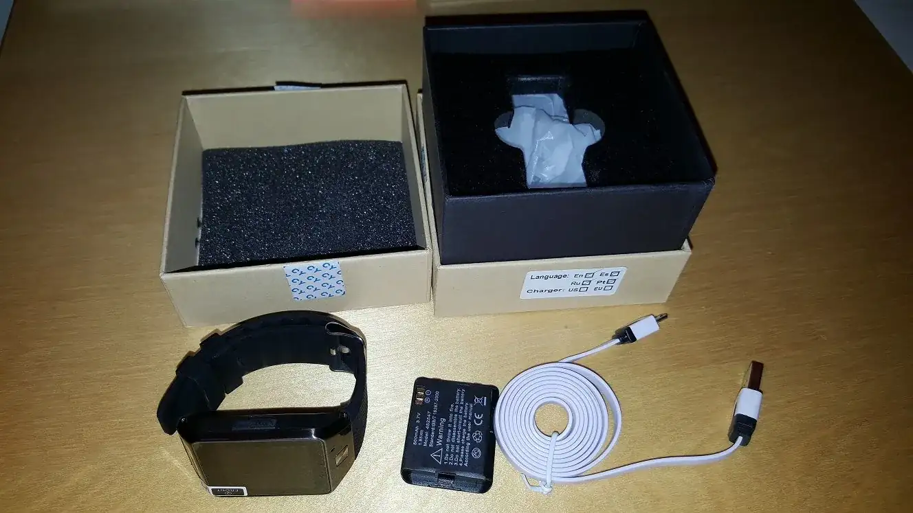 Reloj GV08S junto a su caja, cable USB y batería