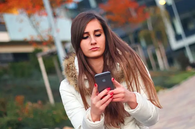 Uso del móvil y redes sociales Joven consultando las redes sociales en su teléfono móvil