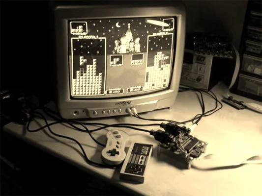 Consola Uzebox con mandos Consola Uzebox conectada a un televisor con dos mandos