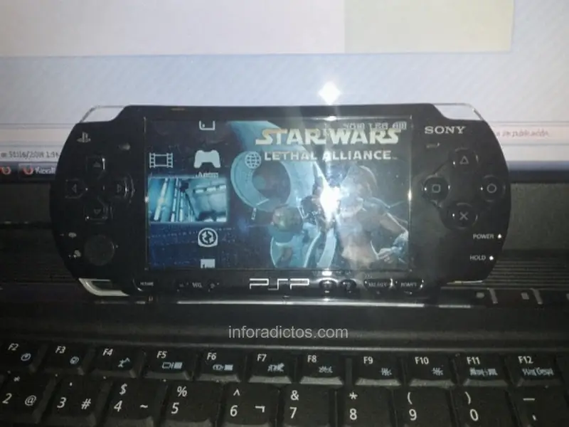 PSP Slim negra con el juego Star Wars Lethal Alliance sobre un teclado