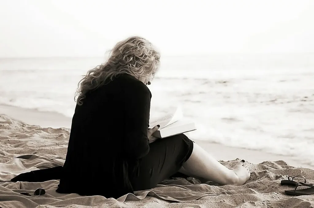 Mujer leyendo a solas junto al mar