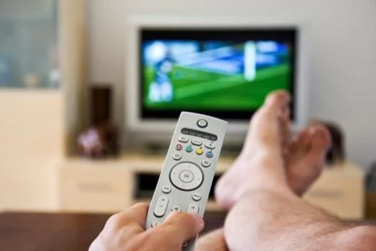 Televisión por streaming Persona utilizando el mando mientras ve televisión por streaming